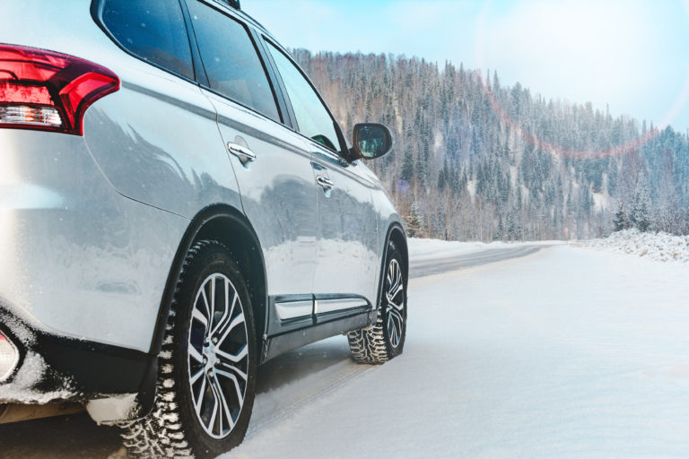 SUV driving down a snow covered mountain road